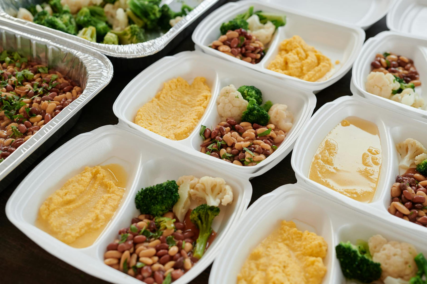 Assorted meal prep containers with beans, broccoli, and mashed potatoes, perfect for healthy eating. on Think Lean Live Strong