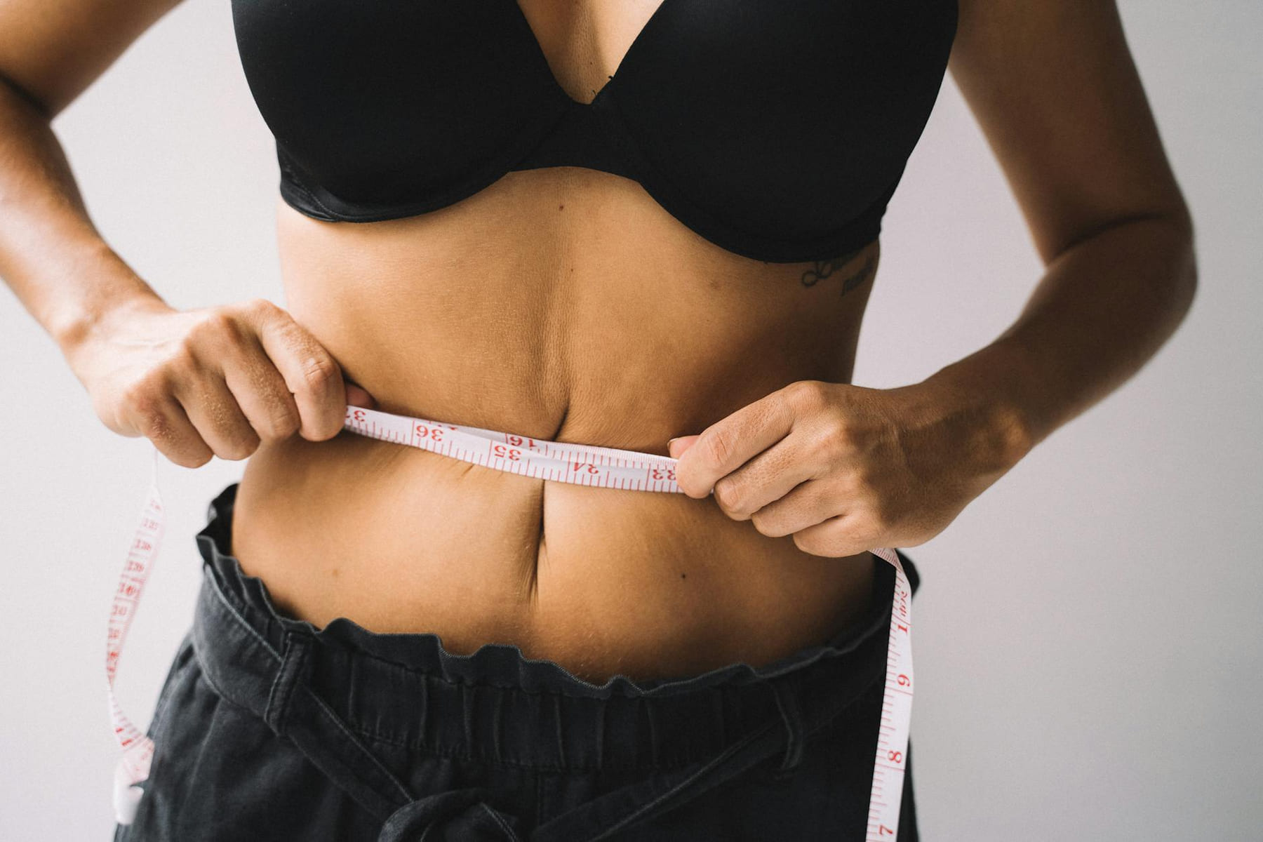 A woman measures her waist with a tape for fitness and weight loss results. on Think Lean Live Strong