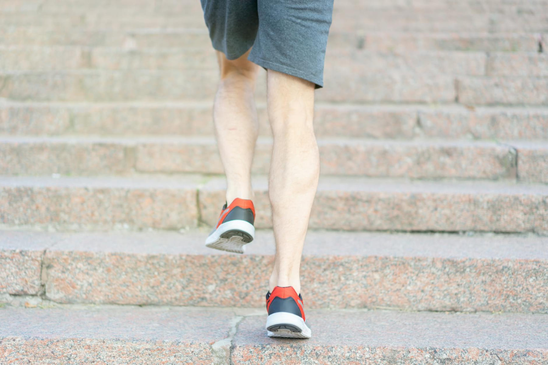 A person in athletic shoes climbing stone steps, showcasing determination and fitness. on Think Lean Live Strong